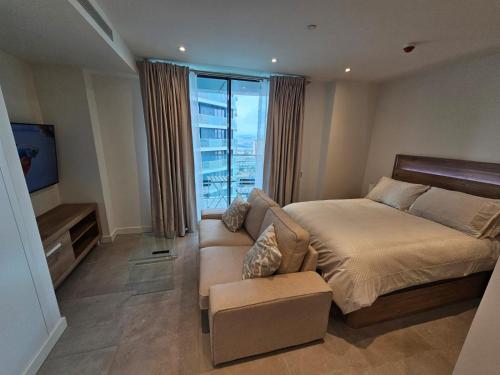 um quarto com uma cama, um sofá e uma janela em Luxury studio in Gibraltar em Gibraltar