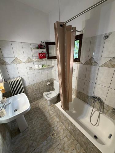 ein Badezimmer mit Waschbecken, Badewanne und Toilette in der Unterkunft Platanaki View in Pýli