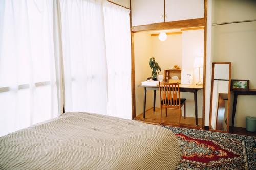 a bedroom with a large bed and a desk at 海に恋する泊まれる喫茶店 ポパイ in Iyo