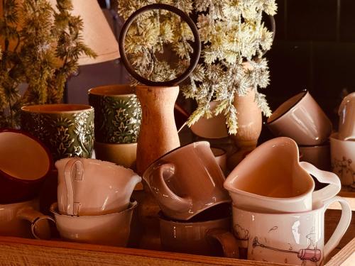 a bunch of cups and a mirror on a shelf at B&B Bad Tiefenau, HAUS AN DER QUELLE in Elgg