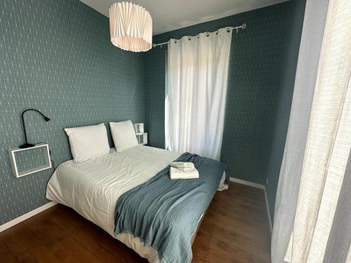 1 dormitorio con 1 cama en una pared verde en Le Magellan Coulommiers 77, en Coulommiers