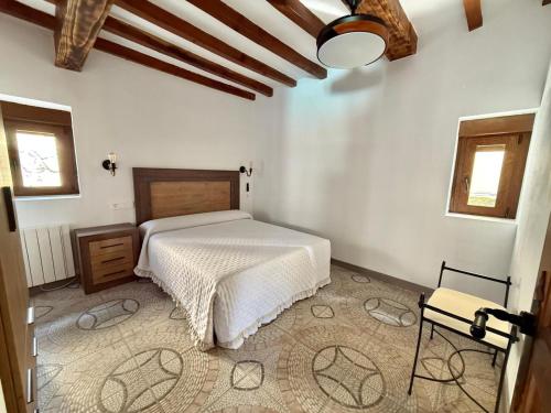 a bedroom with a white bed in a room at La Casa de los Testarros in Gavilanes