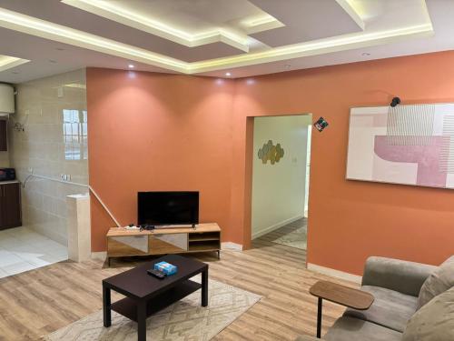 a living room with a couch and a tv at اياد بامالك in Taif