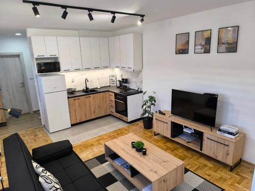 a living room with a couch and a table and a kitchen at Apartman Stefani in Pirot