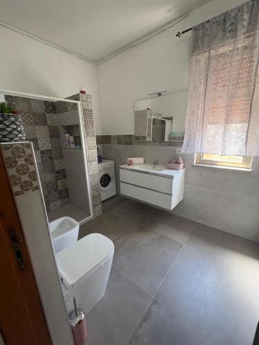 a bathroom with a toilet and a sink and a mirror at A pantanello da Nuzzo in Avola