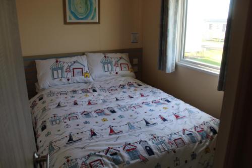 a bed in a bedroom with a bedspread with boats on it at Clearsands at Haven in Mablethorpe