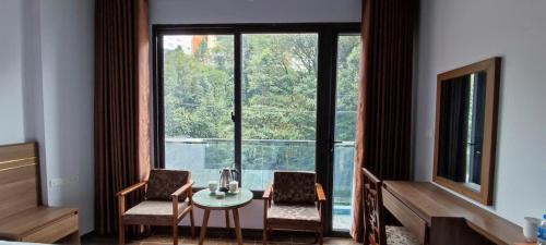 a room with a table and chairs and a large window at Khách sạn Rosalia in Tam Ðảo