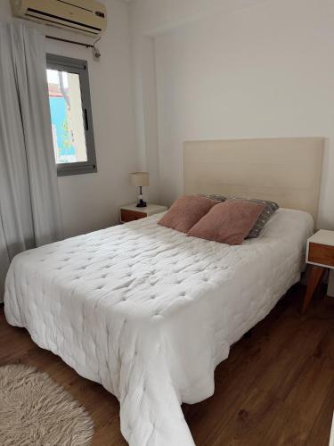a large white bed in a bedroom with a window at Amplio departamento en Bv Galvez in Vuelta del Paraguayo
