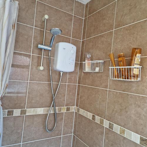 a shower with a blow dryer in a bathroom at Single Bedroom in the main Bungalow in Wednesfield