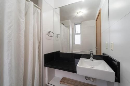 ein weißes Badezimmer mit Waschbecken und Spiegel in der Unterkunft Altos Del Plata 105 y 505 Colonia Uruguay in Colonia del Sacramento