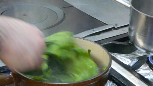 a person is stirring a pot of food on a stove at Hostellerie d'Héloïse Logis in Cluny