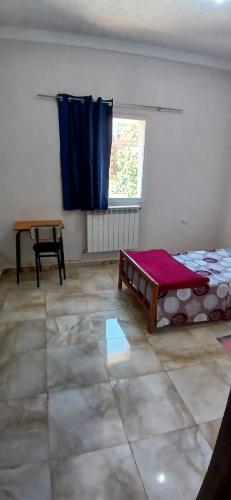 a room with a bed and a table and a window at Hostel 1er novembre khenchela in Khenchela