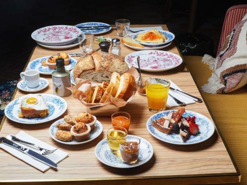 una mesa de madera cubierta con platos de desayuno en Mama Shelter Roma, en Roma