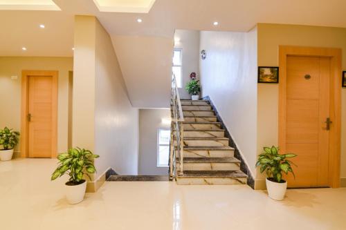 a staircase in a house with two potted plants at FabHotel JP - Nr Sataragachhi Railway Station in Hāora