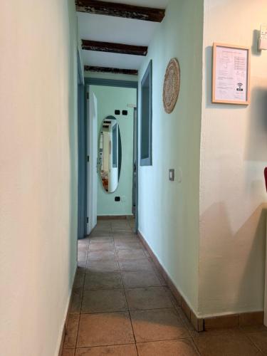 a corridor of a hallway with white walls and a tile floor at Vacacionales Vegueta in Las Palmas de Gran Canaria