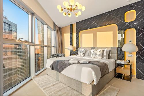 a bedroom with a large bed and large windows at Desert Key Apartments - Al Reem Island in Abu Dhabi
