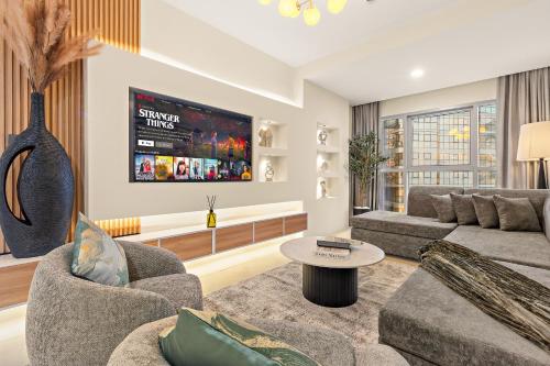 a living room with two couches and a tv at Desert Key Apartments - Al Reem Island in Abu Dhabi