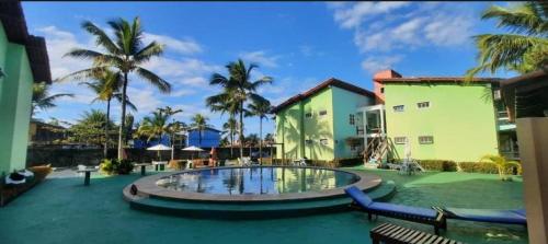 una piscina di fronte a un edificio con palme di Golden Dolphin Taperapuan Apt 529 a Porto Seguro