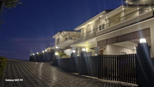 a building with a fence in front of it at night at Queen's Villa Yercaud in Yercaud