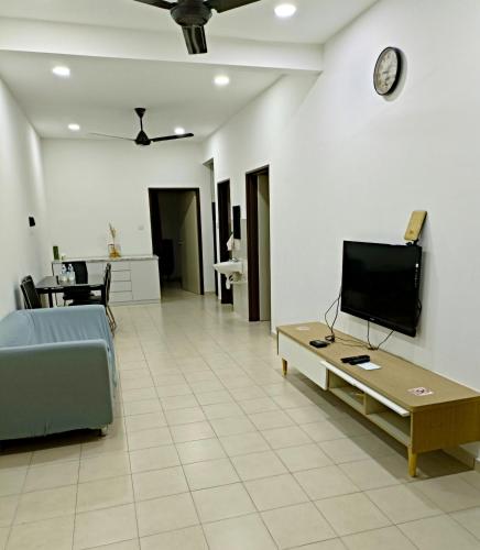 un salon avec un canapé et une télévision sur un mur dans l'établissement Infinity Homestay Bandar Cemerlang, à Ulu Tiram