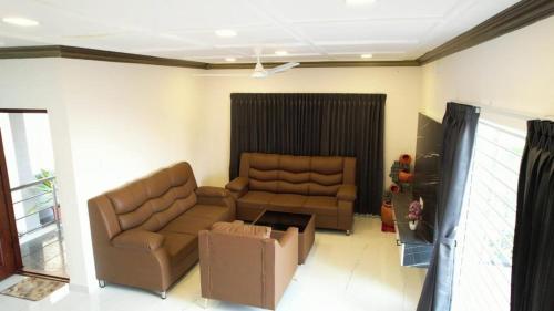 a living room with a couch and a chair at Queen's Villa Yercaud in Yercaud