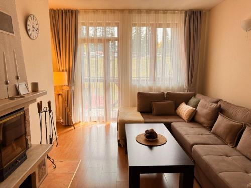 パンポロボにあるGardenia Apartment Pamporovoのソファとテーブルのあるリビングルーム