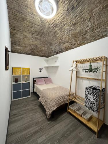 a bedroom with a bed with a wooden ceiling at 150m from the beach in Barcelona