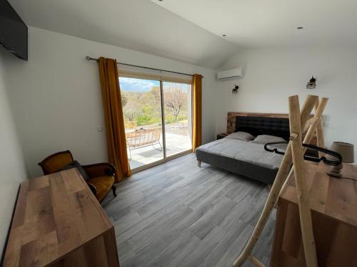 une chambre avec un lit et une grande fenêtre dans l'établissement Gîte Figuier - Village De Gîtes, à Rosières