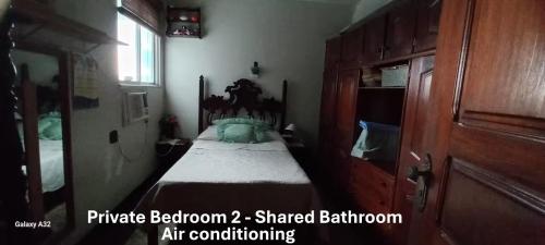 a bedroom with a bed with a wooden head board at Cozy and comfort bedroom in a private Fancy Condo, safety neighborhood only 20 minutes by car from event - COP30! in Belém