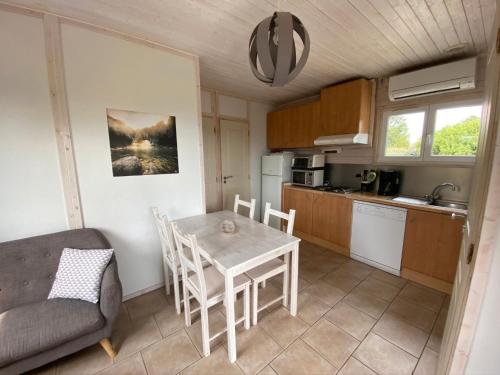 une cuisine et une salle à manger avec une table et des chaises dans l'établissement Gîte Romarin 1 - Village De Gîtes, à Rosières