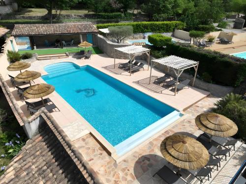 une vue aérienne d'une piscine avec des parasols dans l'établissement Gîte Romarin 1 - Village De Gîtes, à Rosières