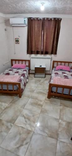 a room with two beds and a window at hostel 1er novembre khenchela in Khenchela