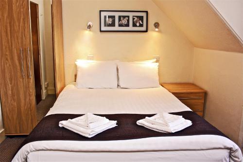 um quarto de hotel com uma cama com toalhas em Central Hotel Golders Green em Londres