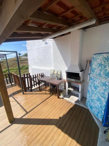 a wooden deck with a table and a grill at Like a Local Guest House in Ericeira