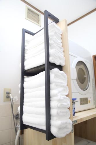 a rack of towels in front of a washing machine at NewOpen, Stella Rinku, りんくうタウン駅徒歩10分, 一棟貸切, 関西空港まで6分 in Izumi-Sano
