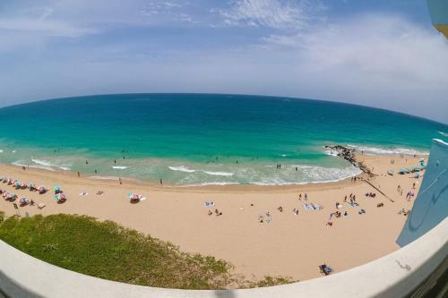 um grupo de pessoas em uma praia perto do oceano em Condado Beachfront- Perfect for Families! em San Juan