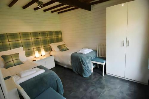 een slaapkamer met twee bedden en een stoel erin bij Mountain Lodge, Lake View, National Park in Borrowdale Valley