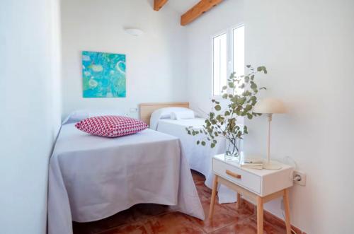 a bedroom with a bed and a table with a lamp at Relax en Villa Tranquila in Cala en Blanes