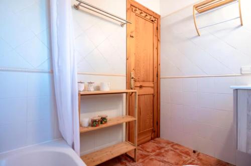 a bathroom with a shower and a wooden door at Relax en Villa Tranquila in Cala en Blanes