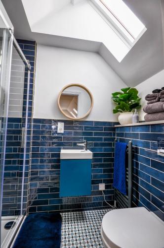 a bathroom with blue tiles and a skylight at Northampton 3 Bed 3 Bathroom New Duplex Apartment in Spinney Hill