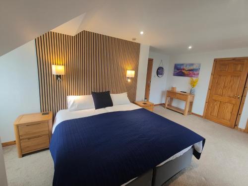 a bedroom with a blue bed and a wooden door at Lochbroom Lodge in Ullapool
