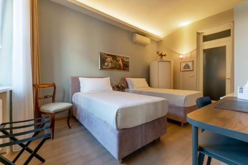 une chambre d'hôtel avec deux lits, une table et un bureau dans l'établissement Cavour Suite Luxury, à Bologne