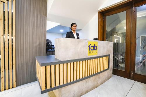 a man is standing behind a reception desk at FabHotel Global Spaces - Nr NESCO Exhibition Center in Mumbai