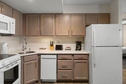 a kitchen with wooden cabinets and a white refrigerator at WorldMark Reno in Reno