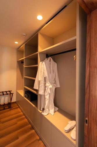 a walk in closet with a white shirt in it at Quinta da Maquia Hotel in Sintra