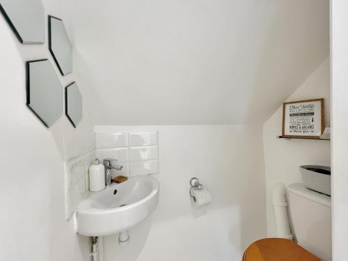 a white bathroom with a sink and a toilet at Chapel Cottage Ellicombe in Dunster