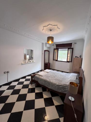 a bedroom with a bed and a checkered floor at Blue Pearl city in Chefchaouene