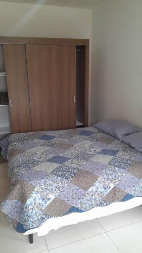 a bed with a quilt on it in a bedroom at Recanto praiano in Torres