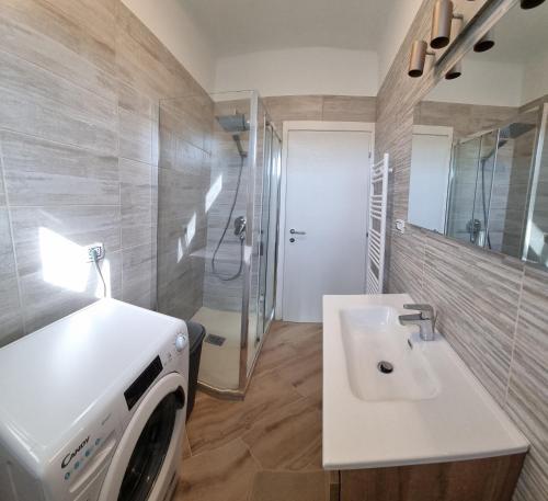 a bathroom with a sink and a washing machine at Sunny CentralApartment -3 bedrooms ,Private Parking in Monfalcone