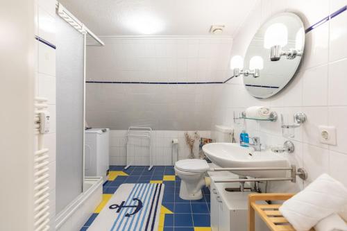 a bathroom with a sink and a toilet and a mirror at Auszeit unter Reet in Dörpum